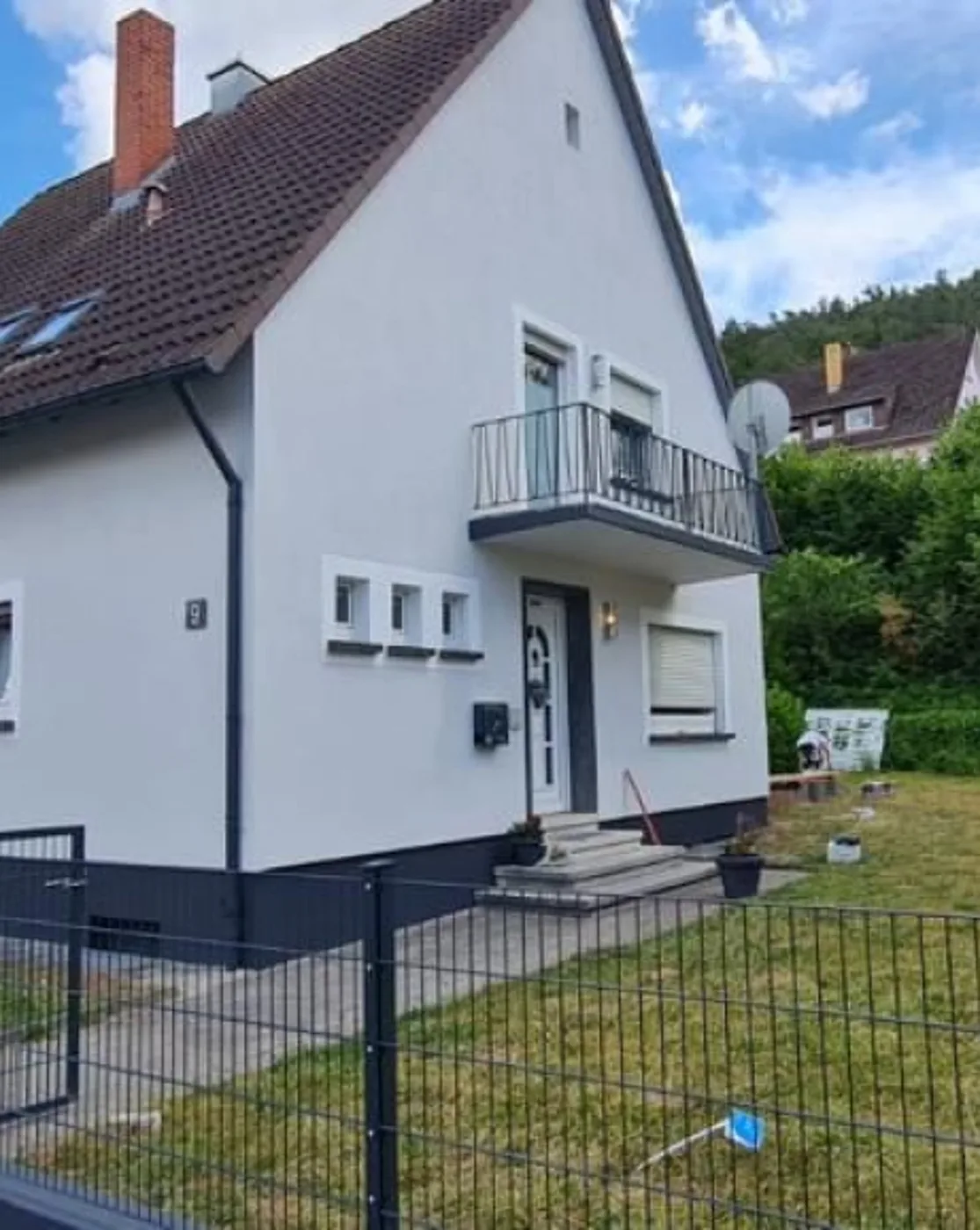 Frisch gestrichene weiße Hausfassade mit Balkon